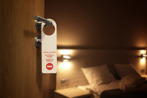 A photo of a hotel door hand with do not disturb sign